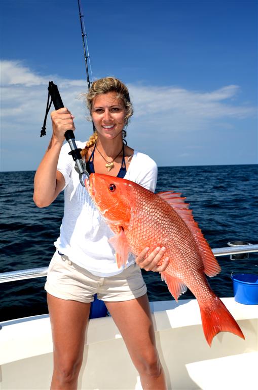 girl-holding-red-snapper-on-distraction-charter-boat