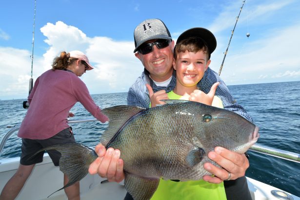 Father son holding triggerfish