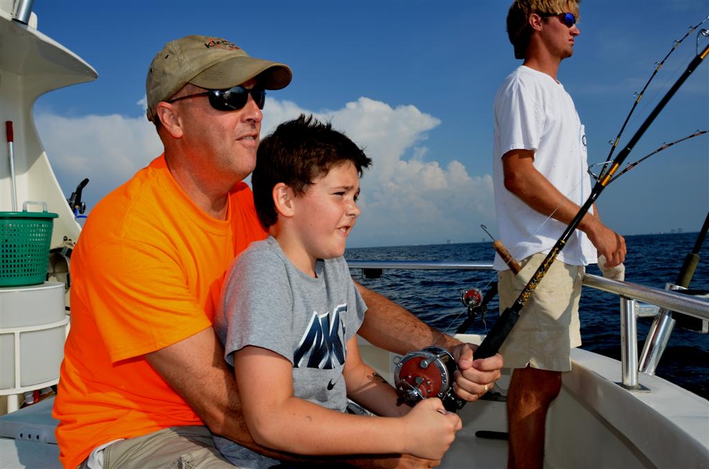 reeling in a big fish while trolling fishing near shore