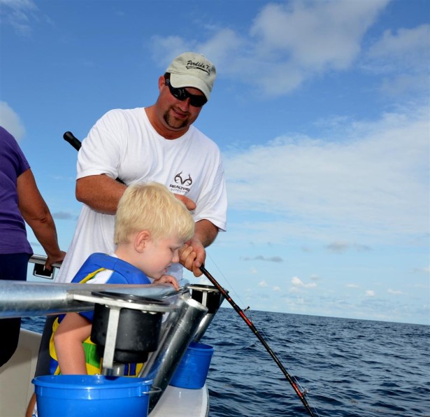 kids fishing with dad on a charter boat